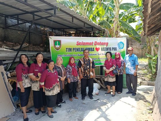 Warga RW 03 berfoto bersama tim penilai lomba Hatinya PKK di lingkungan kampung